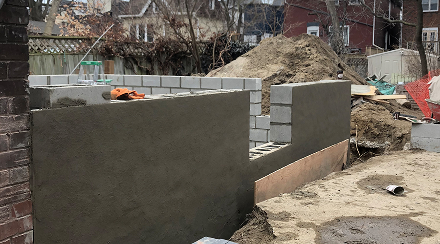 Cinderblock foundation with concrete seal on the outside under construction by Mace Masonry